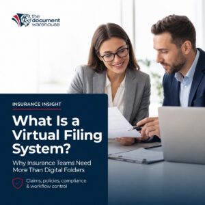 Business professionals reviewing insurance documents beside a laptop, with text reading “What Is a Virtual Filing System?” for an article about document control for insurance teams.